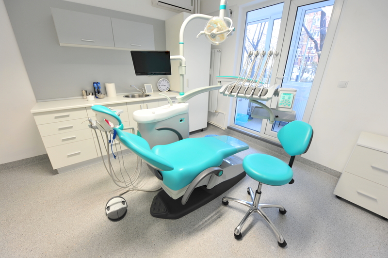 High tech dentistry tools - doctors office. Reclining dental chair and dental care tools inside a doctors office